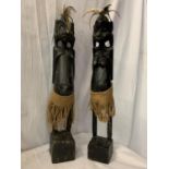 A PAIR OF TREEN TRIBAL FIGURES WITH FEATHER EMBELLISHMENT