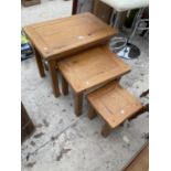 A MODERN OAK NEST OF THREE TABLES