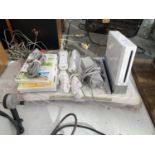 A NINTENDO WII, WII FIT BOARD, TWO CONTROLLERS AND GAMES
