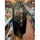 A LARGE SILK EMBROIDERED BLACK TASSELLED SHAWL