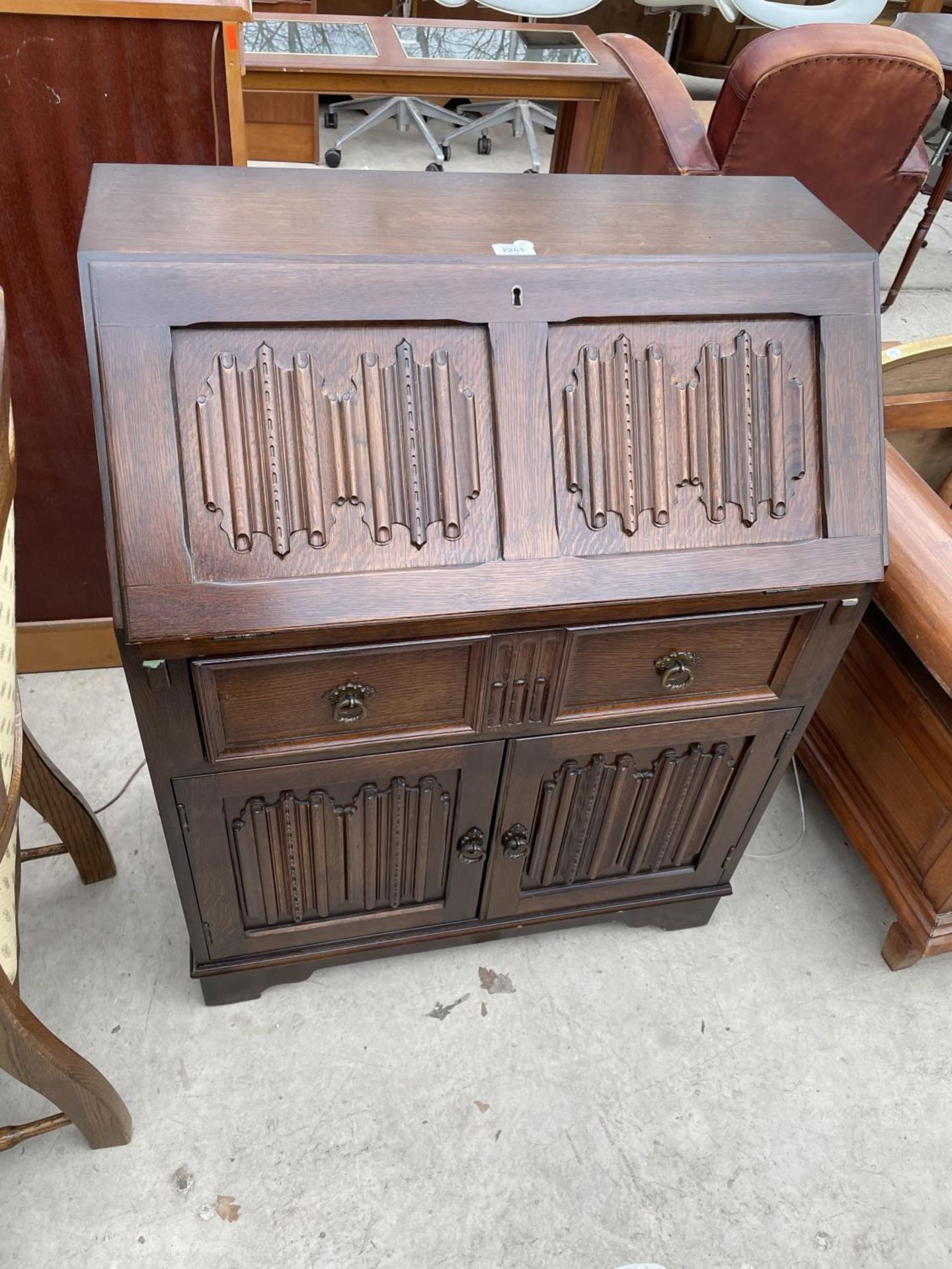 AN OAK REPRODUX STYLE LINENFOLD BUREAU, 30" WIDE