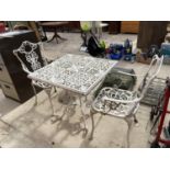 A WHITE CAST IRON BISTRO SET WITH SQUARE TABLE AND TWO CHAIRS