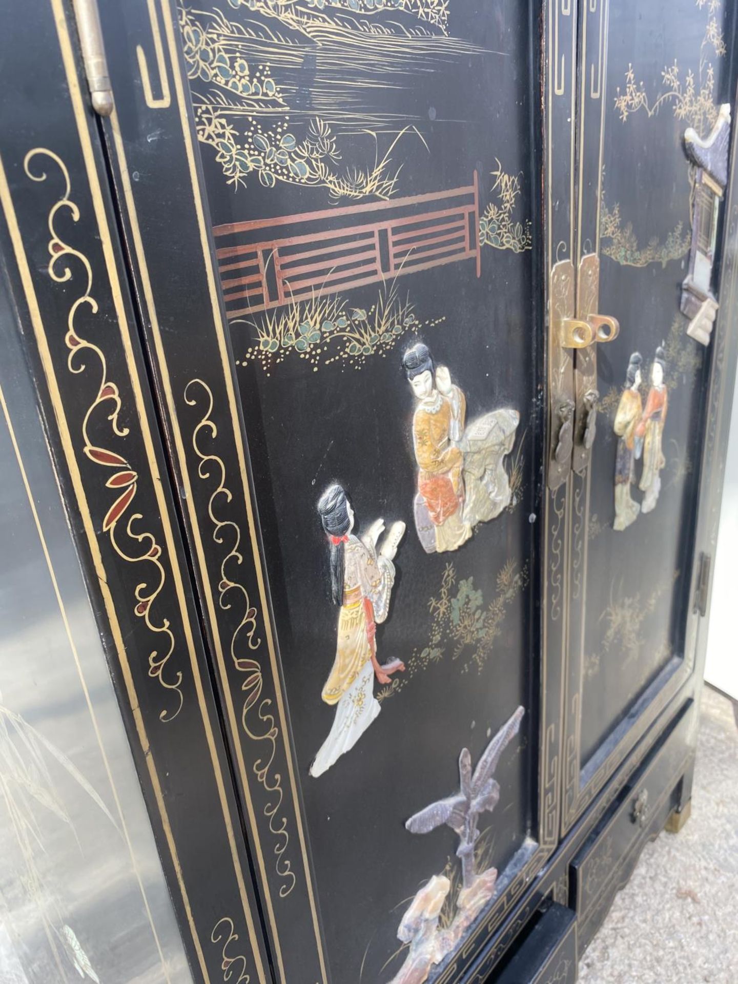 AN ORIENTAL BLACK LAQUER TWO DOOR CABINET WITH BASE DRAWERS, 24" WIDE WITH RAISED DECORATIONS - Image 4 of 4