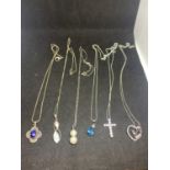 SIX MARKED SLIVER PENDANTS ON CHAINS TO INCLUDE A CLEAR STONE CROSS, HEART, BLUE STONE, PEARL ETC