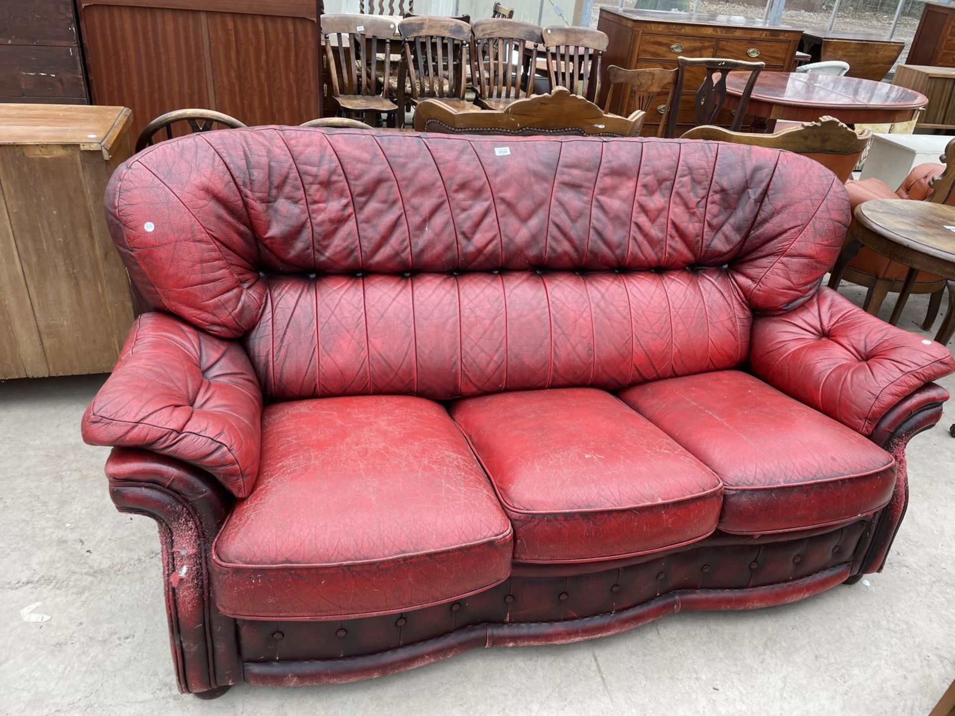 AN OXBLOOD THREE SEATER SETTEE