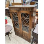 AN OAK PRIORY STYLE GLAZED AND LEADED BOOKCASE