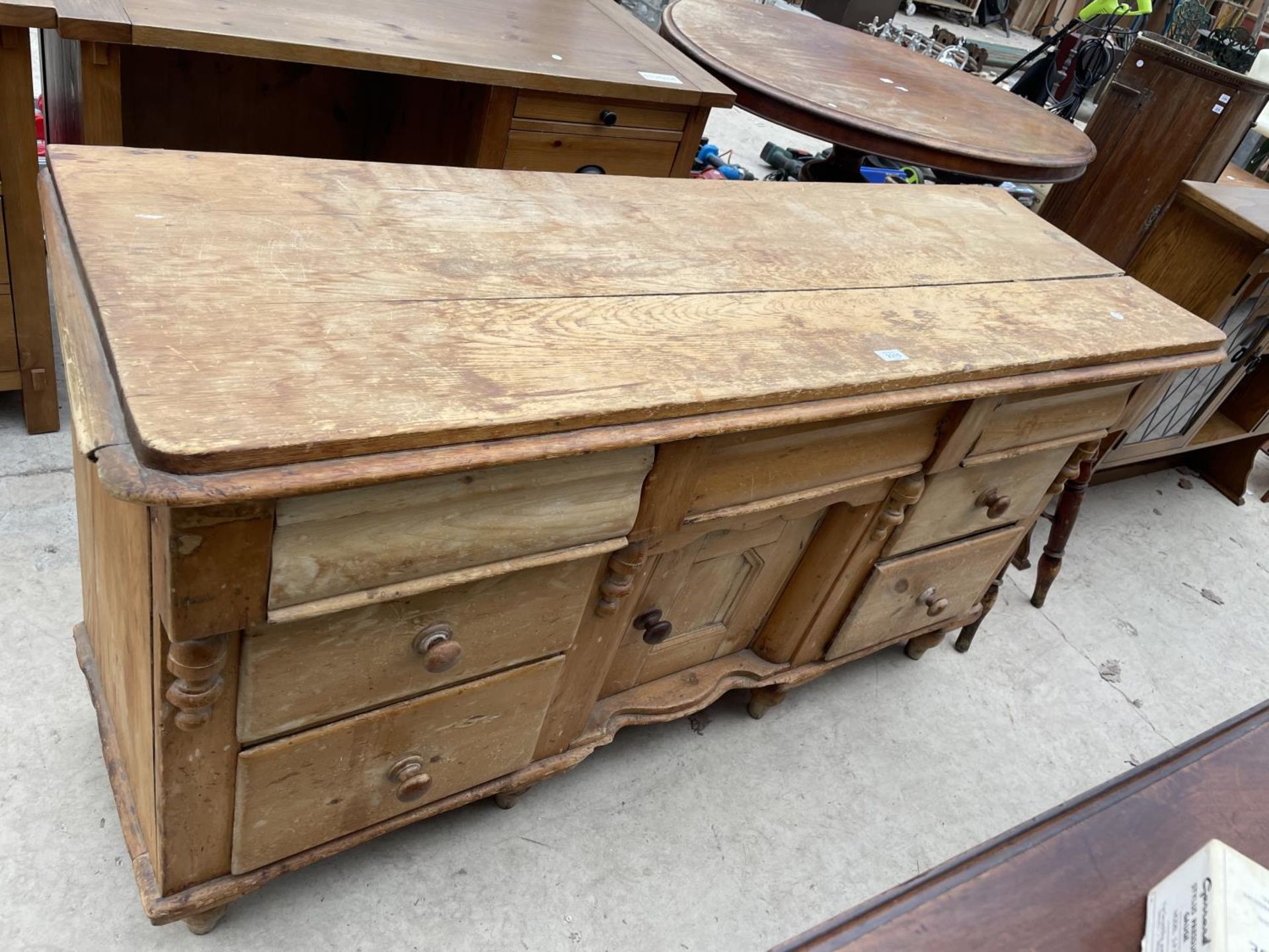 A VICTORIAN PINE KITCHEN DRESSER BASE ENCLOSING SIX DRAWERS AND CENTRAL CUPBOARD, 61" WIDE