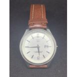 A WRISTWATCH WITH A TAN LEATHER STRAP IN WORKING ORDER