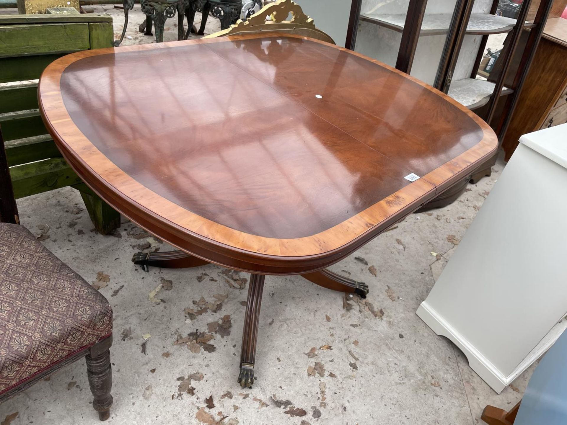 A REGENCY STYLE CROSSBANDED YEW WOOD EXTENDING DINING TABLE