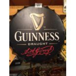 A METAL WALL HANGING 'GUINNESS' BOTTLE CAP SIGN