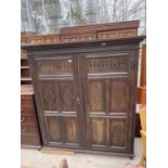 A GEORGE III OAK TWO DOOR WARDROBE WITH CARVED FRONT PANELS AND METALWARE FITTINGS W: 63" WIDE,