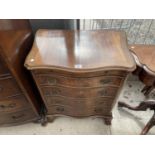 A REPRODUCTION MAHOGANY AND CROSSBANDED SERPENTINE FRONTED CHEST OF FOUR DRAWERS WITH SLIDE W: 27