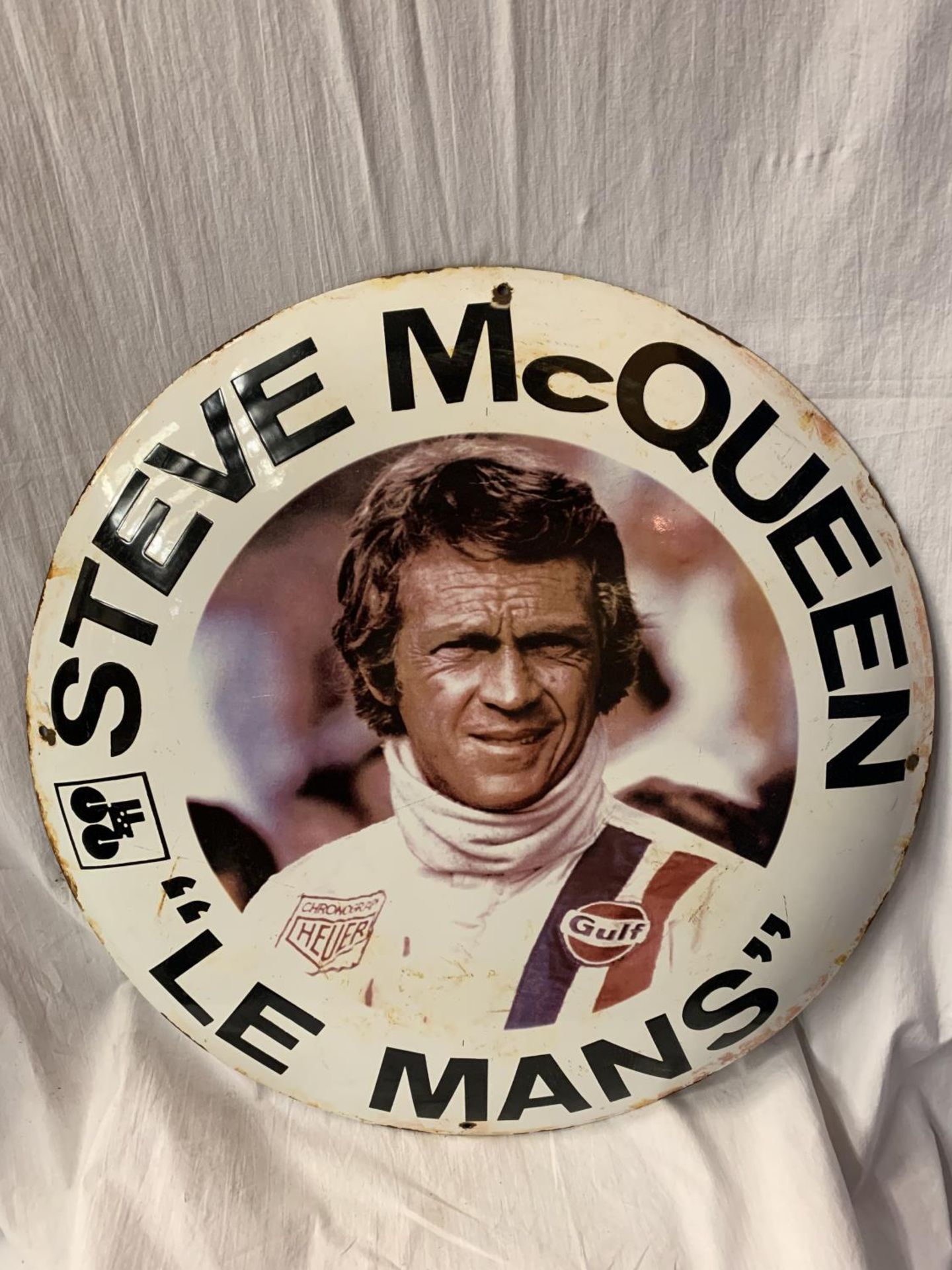 A LARGE ROUND ENAMEL 'STEVE MCQUEEN "LE MANS" ' SIGN DIAMETER 60CM