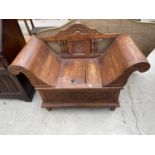 AN INDONESIAN HARDWOOD SEAT WITH SCROLL ENDS, CARVED BACK WITH SPINDLES AND LIFT-UP LID FOR