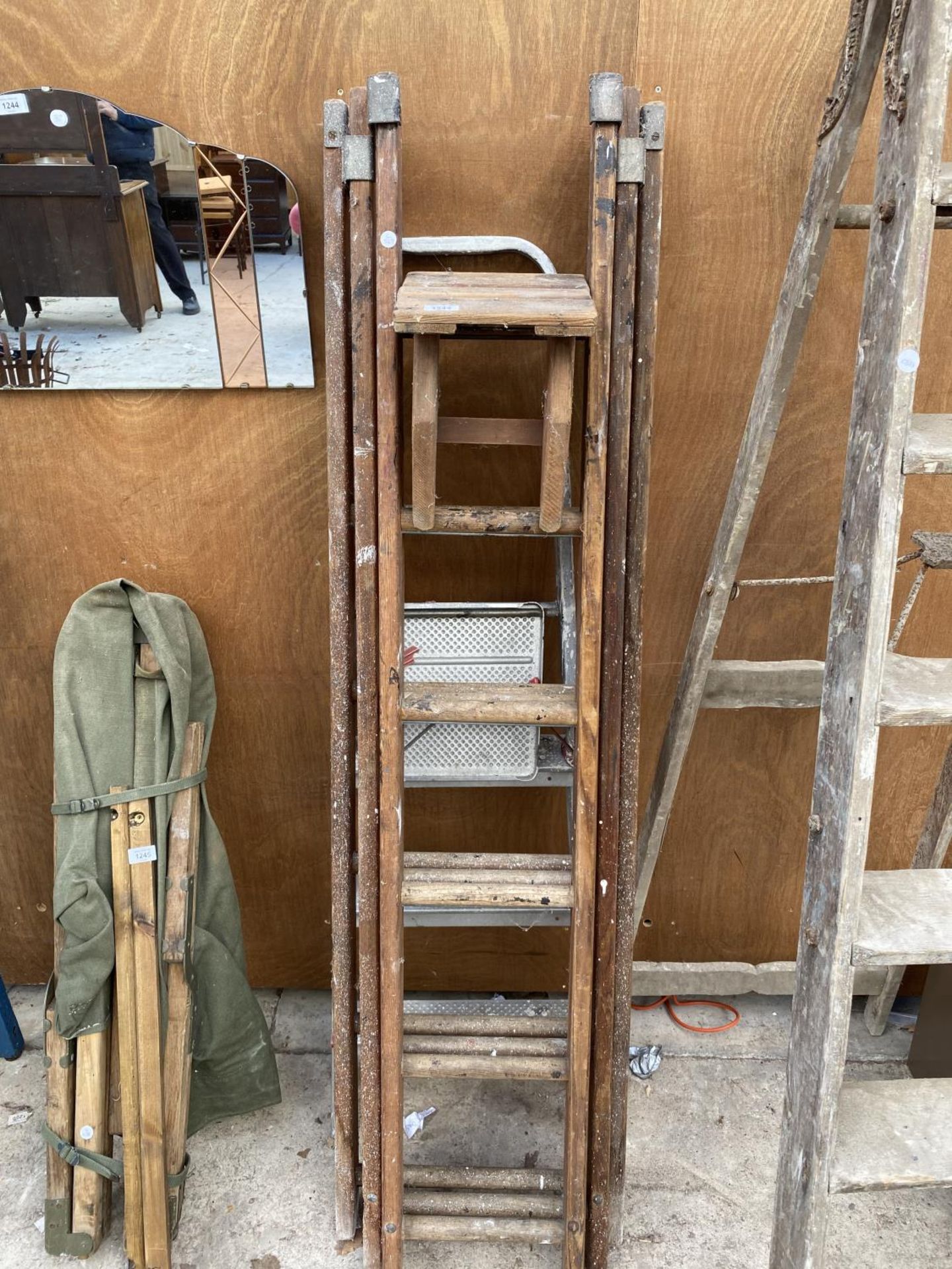 A THREE SECTION WOODEN LADDER AND A FURTHER THREE RUNG ALUMINIUM STEP LADDER