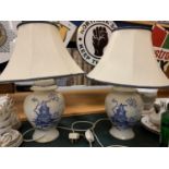 A PAIR OF CERAMIC BASED BLUE AND WHITE TABLE LAMPS COMPLETE WITH SHADES H: TO BOTTOM OF BULB 37CM