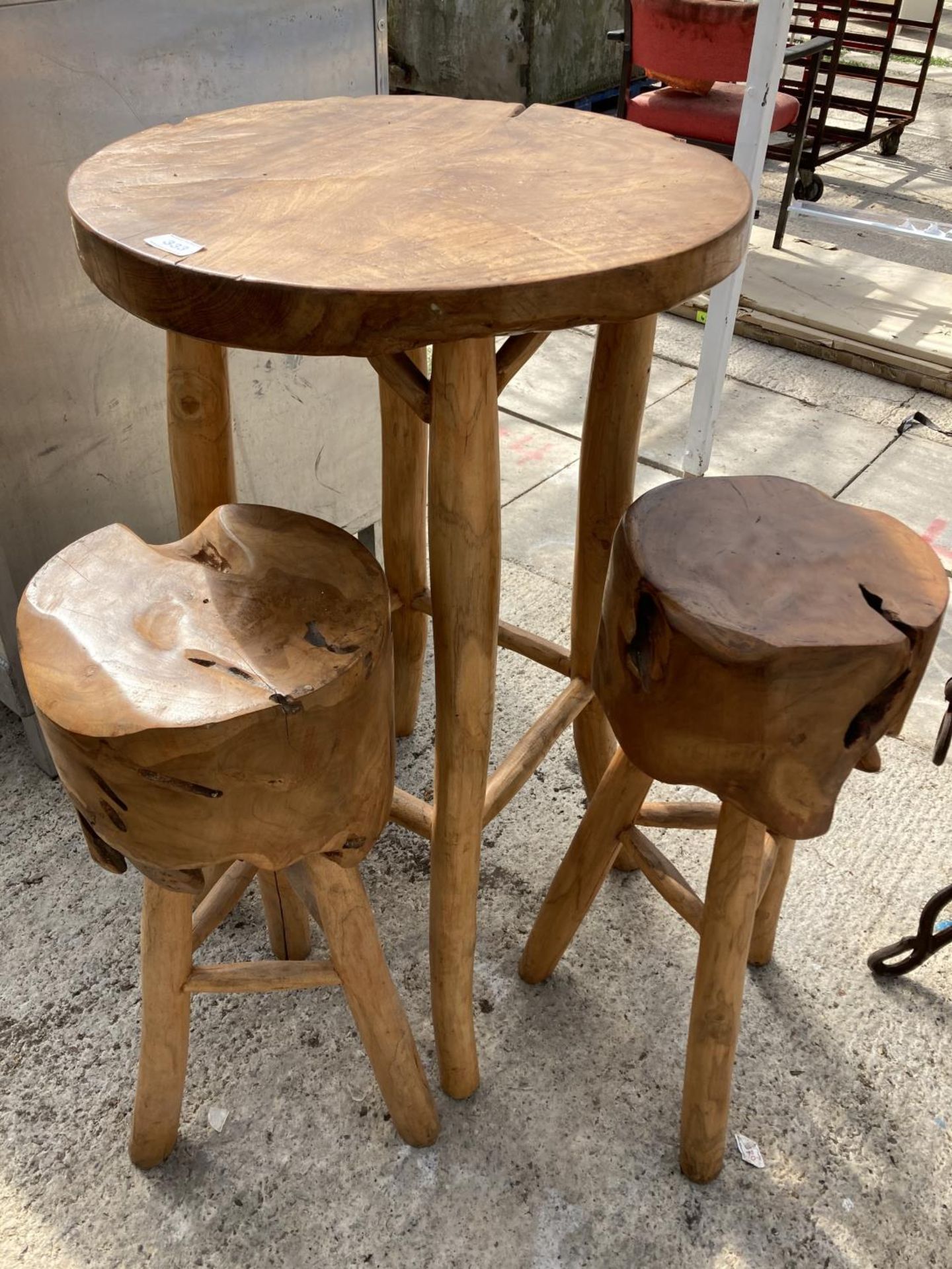 A WOODEN TABLE AND TWO LOG TOPPED STOOLS NO VAT