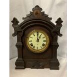 AN EBONISED MANTEL CLOCK WITH DECORATIVE EDGING AND BRASS DETAIL