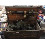 A VINTAGE MILITARY MINE DETECTOR AND TWO PAIRS OF VINTAGE BINOCULARS IN WOODEN MILITARY CASE