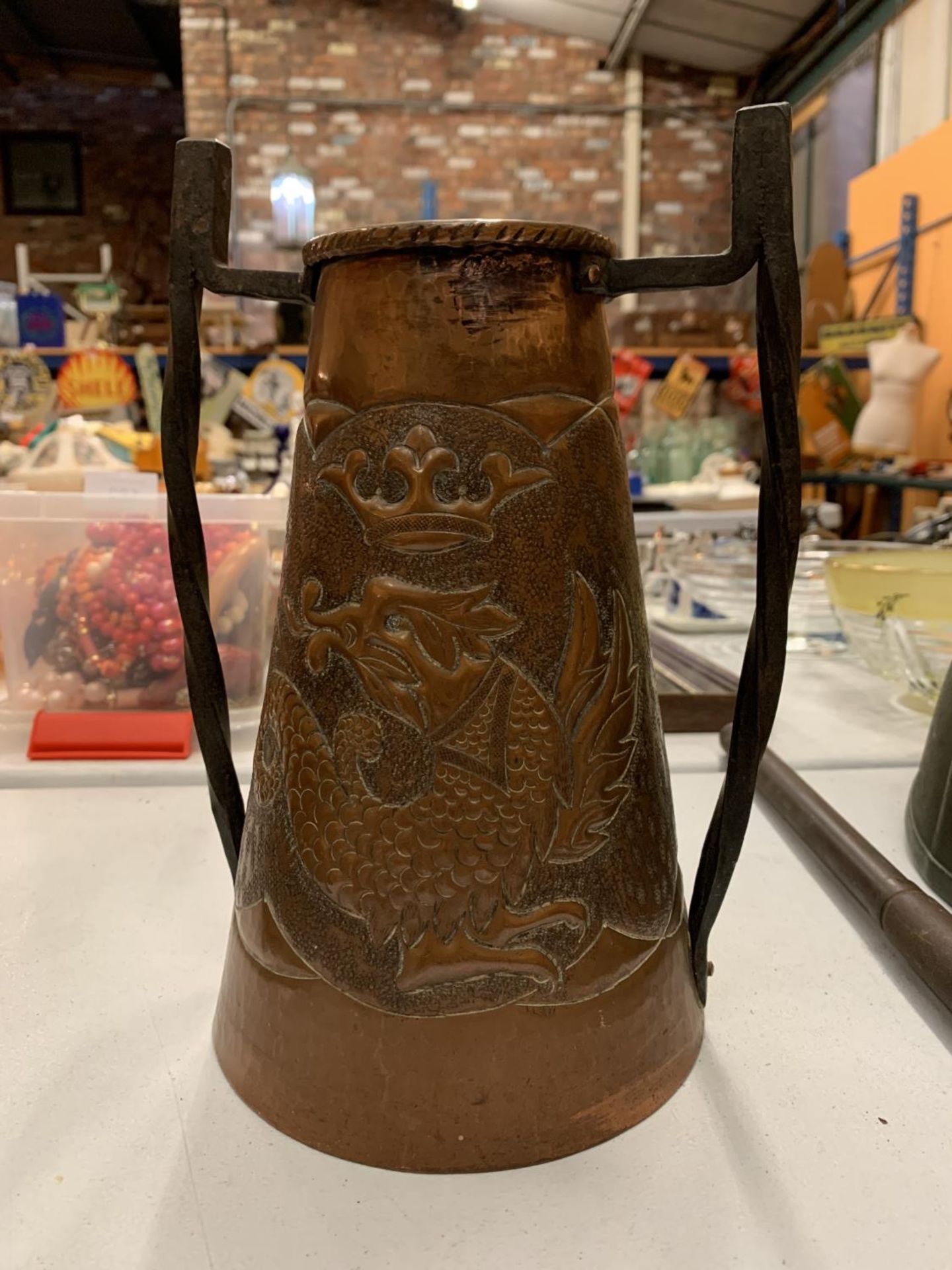 AN ARTS & CRAFTS COPPER AND IRON HANDLED VASE WITH EMBOSSED DRAGON AND CROWN DECORATION