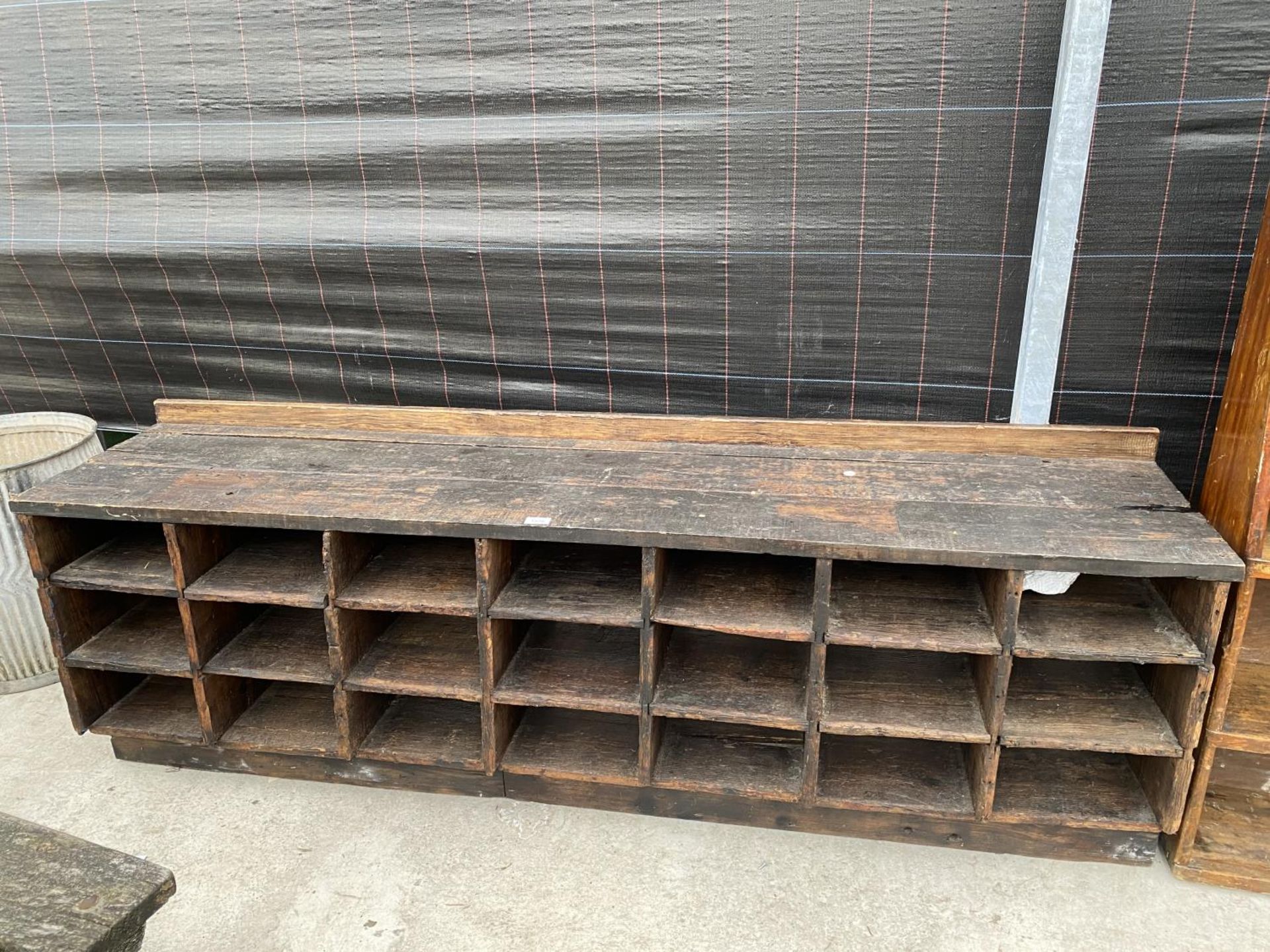 A VINTAGE WOODEN 21 SECTION PIGEON HOLE STORAGE BENCH