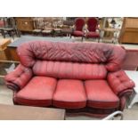 AN OXBLOOD THREE SEATER SETTEE