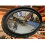 AN OVAL MIRROR WITH A PAINTED FRAME