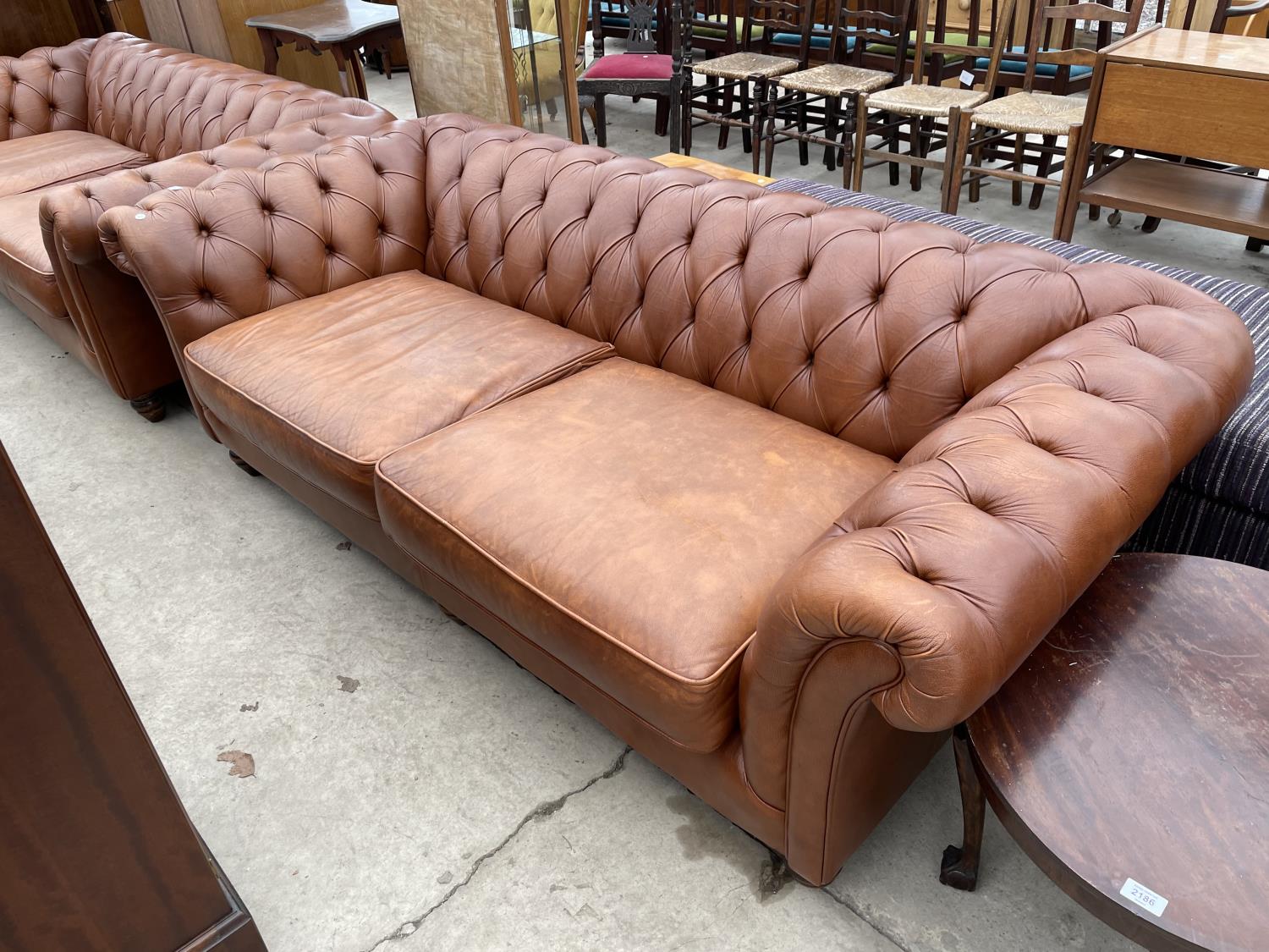 A TAN LEATHER LOW BACK TWO SEAT CHESTERFIELD SOFA