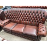 AN OXBLOOD 3 SEATER BUTTON BACK SETTEE