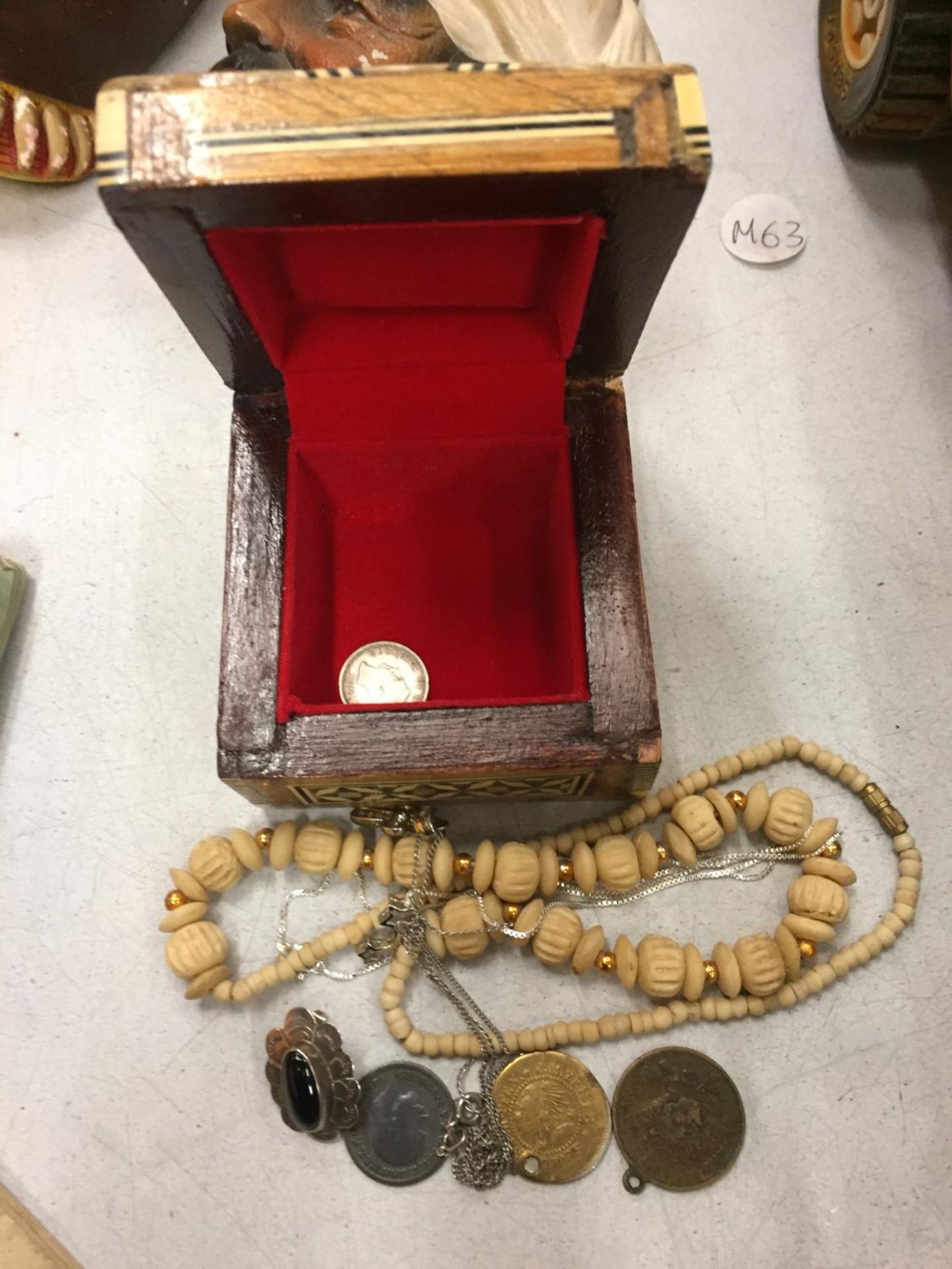 A SMALL DECORATIVE BOX AND CONTENTS CONSISTING OF COINS AND NECKLACES