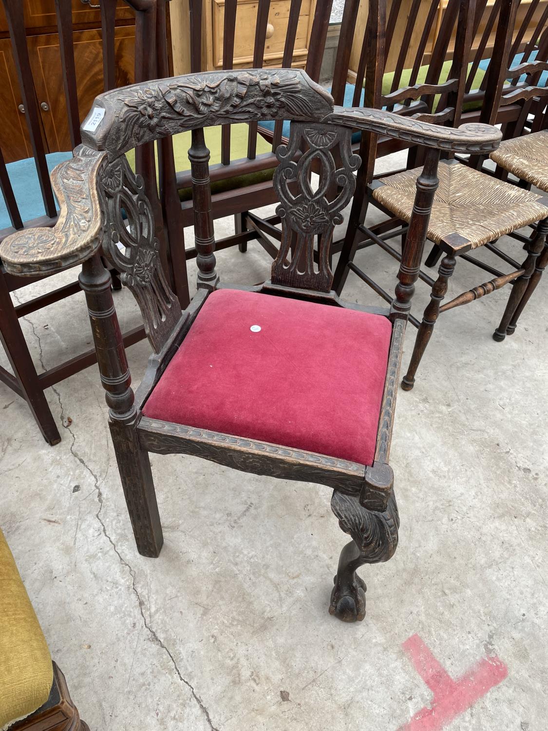 A VICTORIAN HEAVILY CARVED CORNER CHAIR WITH PIERCED SPLAT BACKA ND FRONT CABRIOLE LEG WITH BALL AND