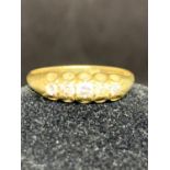 AN 18 CARAT YELLOW GOLD RING WITH FIVE IN LINE DIAMONDS - 3.1 GRAMS, RING SIZE O