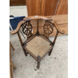 AN OAK GEORGIAN CORNER CHAIR WITH TURNED UPRIGHTS AND PIERCED SPLAT BACK WITH RUSH SEAT