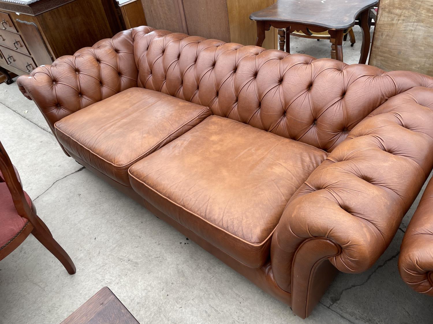 A TAN LEATHER LOW BACK TWO SEAT CHESTERFIELD SOFA