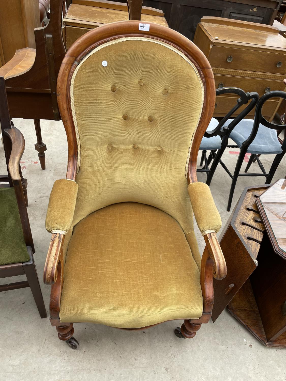 A VICTORIAN MAHOGANY FRAMED OPEN ARM FIRESIDE CHAIR WITH BUTTON BACK