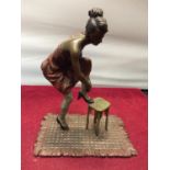 A BERGMAN STYLE COLD PAINTED FIGURINE OF A LADY WITH HER FOOT ON A STOOL HEIGHT APPROXIMATELY 12CM