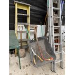 AN ASSORTMENT OF ITEMS TO INCLUDE TWO WOODEN STEP LADDERS, A WHEEL BARROW AND GARDEN TOOLS