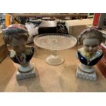 A PAIR OF CERAMIC BUSTS OF CHILDREN AND A GLASS CAKE STAND