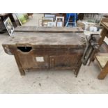 A VINTAGE WORK BENCH ENCLOSING A CUPBOARD UNDERNEATH AND A BLACKSMITHS VICE