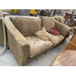 A VICTORIAN STYLE SPRUNG AND UPHOLSTERED THREE SEATER SETTEE AND CHAIR ON TURNED LEGS WITH BRASS