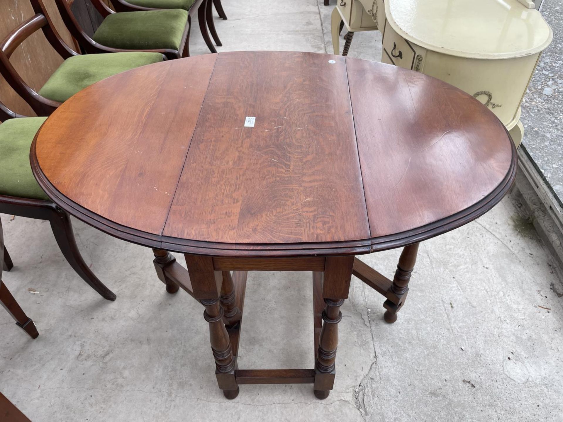 AN EARLY 20TH CENTURY OVAL OAK DINING TABLE ON TURNED LEGS, 30X42"