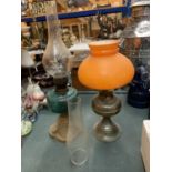 TWO VINTAGE OIL LAMPS ONE WITH AN ORANGE SHADE