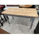 A LONG PINE KITCHEN TABLE ON A GREY PAINTED BASE