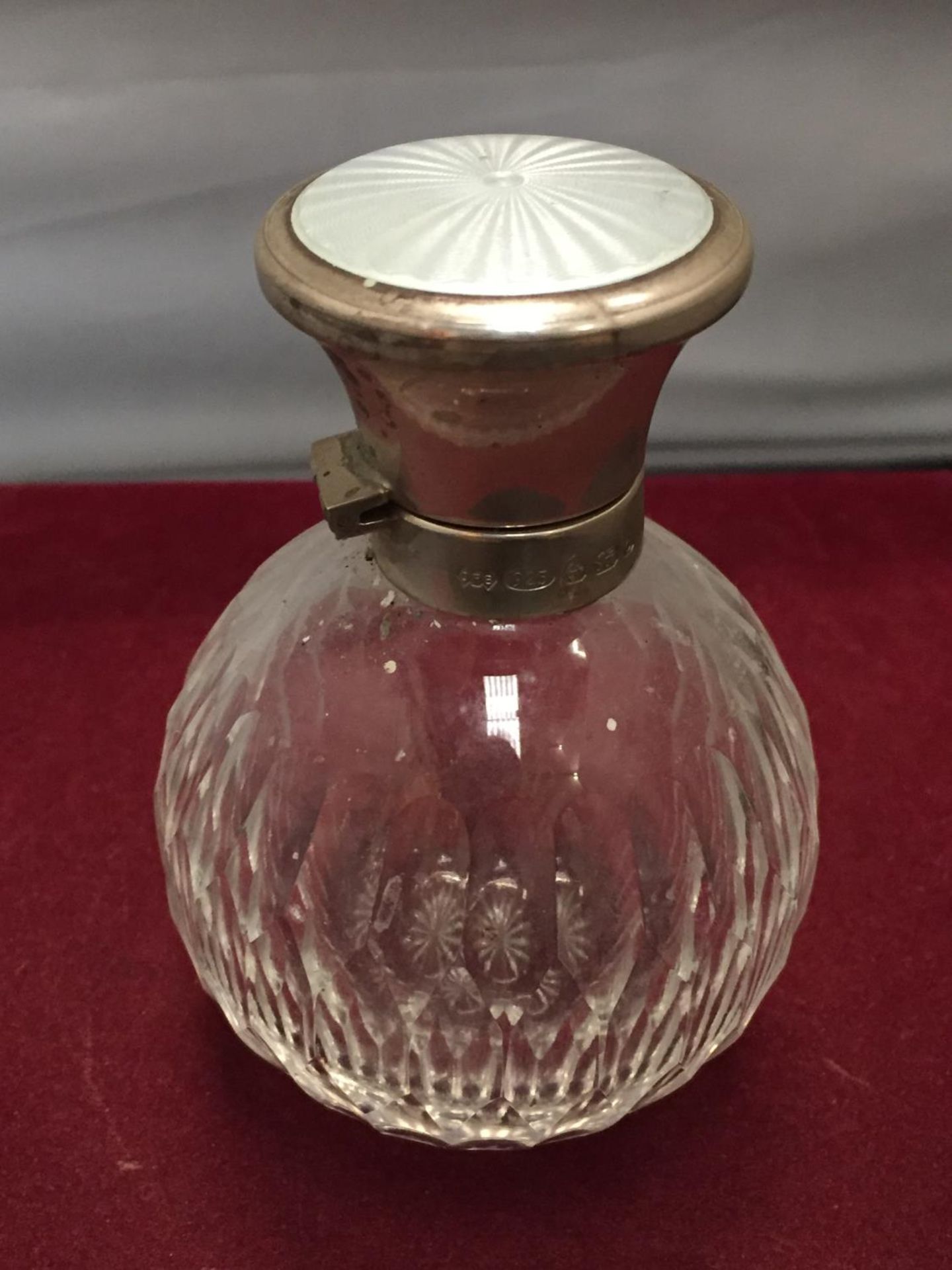 A SCENT BOTTLE WITH A HALLMARKED SILVER AND ENAMEL TOP