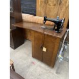 A SINGER ELECTRIC SEWING MACHINE IN CABINET
