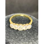 AN 18 CARAT YELLOW GOLD RING WITH CENTRE DIAMOND AND FOUR FURTHER GRADUATED IN LINE DIAMONDS - 2.6