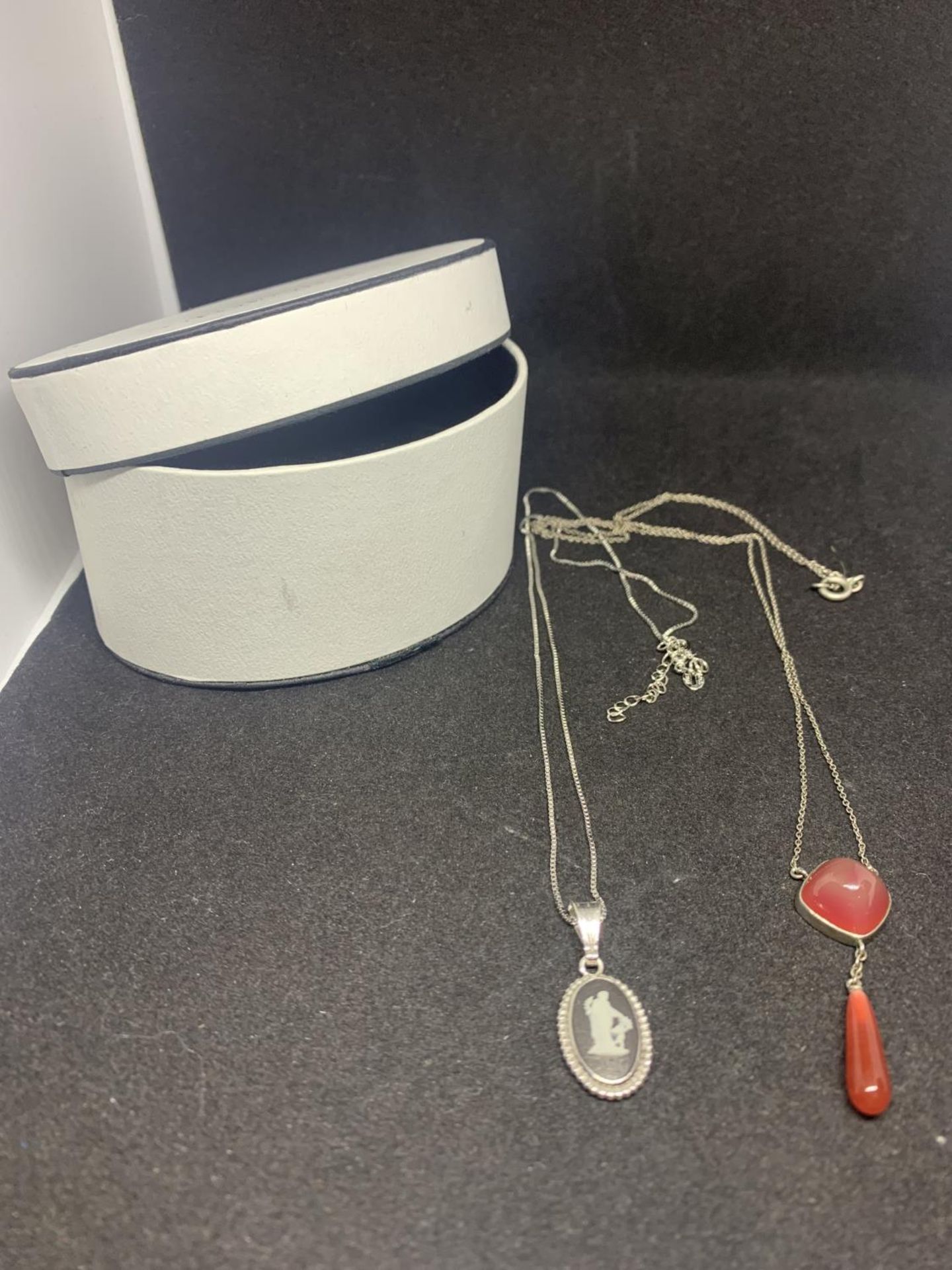 TWO SILVER NECKLACES WITH PENDANTS TO INCLUDE A BLACK JASPERWARE AND A RED STONE WITH DROP