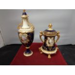 TWO ORNATE LIDDED URNS WITH DARK BLUE AND GILT DECORATION A/F HAIRLINE CRACK ON SMALLER URN