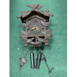 A DECORATIVE WOODEN CUCKOO CLOCK WITH WEIGHTS