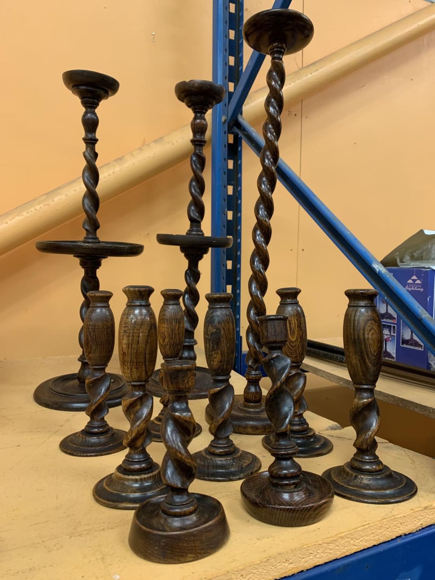 A SELECTION OF ELEVEN WOODEN CANDLESTICKS OF VARIOUS SIZES THE TALLEST BEING 68CM HIGH AND THE